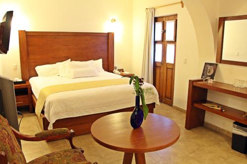 克雷塔罗艾尔斯拉弗恩精品酒店的酒店客房配有一张床铺和一张桌子。