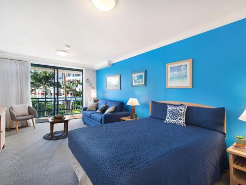 黄金海岸Calypso Plaza Resort Unit 215的蓝色的卧室配有床和沙发