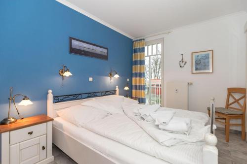 奥斯赛拜-屈隆斯博恩Duenenschloss-Haus-2-Wohnung-13-274的卧室配有白色床和蓝色墙壁