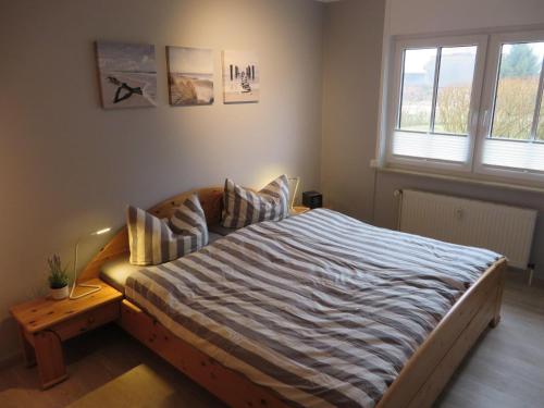 奥斯赛拜-屈隆斯博恩Ferienanlage-Reriker-Strasse-Bella-Vista-736的一间卧室配有一张带条纹床单的大床
