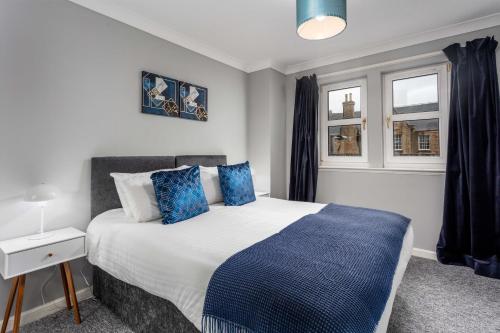 艾尔Millbrae Residence - Donnini Apartments的一间卧室配有一张带蓝色枕头的大床