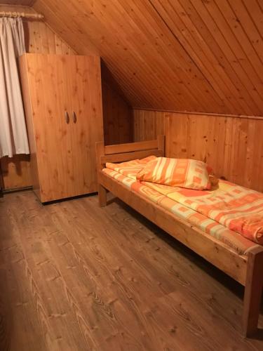 哈尔吉塔拜Hargitafürdői Vendégház的小木屋内一间卧室,配有一张床