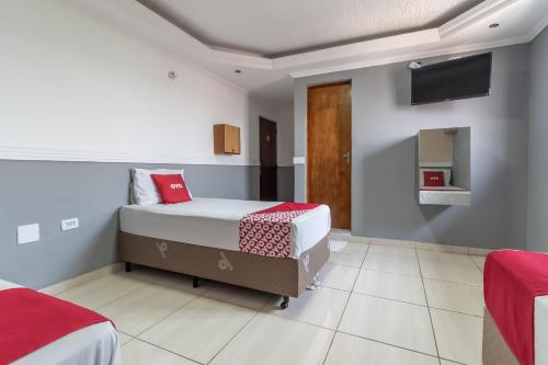圣保罗OYO Hotel San Remo, São Paulo的一间卧室设有两张床,墙上配有电视。