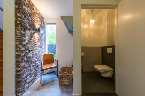 贝克Vakantiehuis Le Platane - in natuurgebied nabij Nijmegen的一间带卫生间和砖墙的浴室