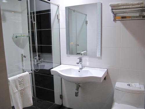 山打根拉卜酒店的一间带水槽、淋浴和卫生间的浴室