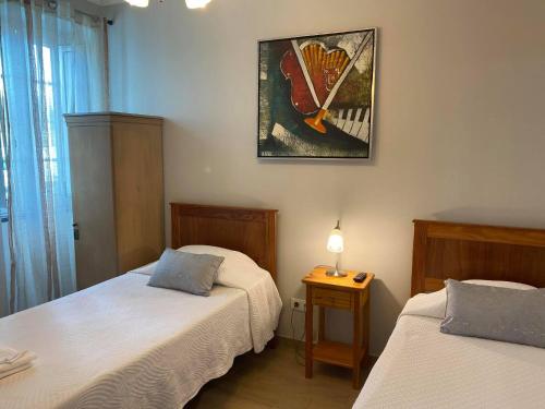 英雄港Hospedaria Isaias的卧室配有两张床,墙上挂着一幅画