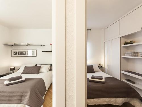 巴塞罗那Lets holidays apartment in Sant Martí的卧室设有2张床和白色的墙壁。