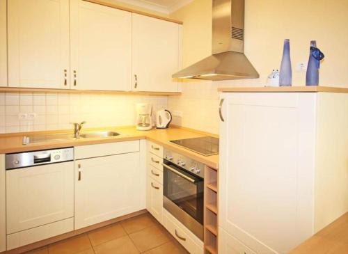 奥斯赛拜-屈隆斯博恩Residenz-Ostseestrand-Wohnung-4-9624的厨房配有白色橱柜和水槽