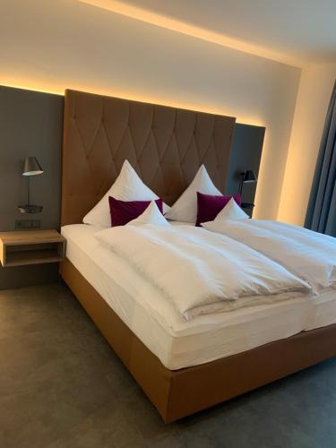 皮尔马森斯Emils Hotel的卧室配有带红色枕头的大型白色床