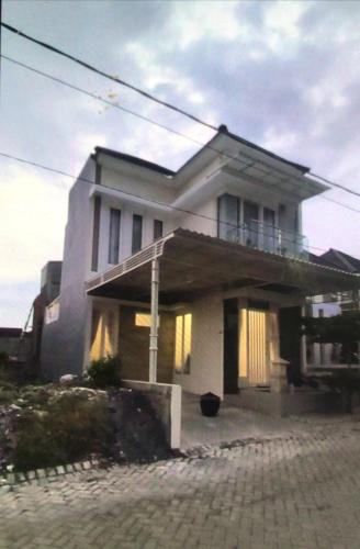 巴图VILLA BAGUS KAYANA H2 DI BATU JAWA TIMUR的一座大型白色房子,上面设有阳台
