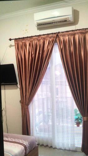 巴图VILLA BAGUS KAYANA H2 DI BATU JAWA TIMUR的一间卧室设有窗户、窗帘和空调