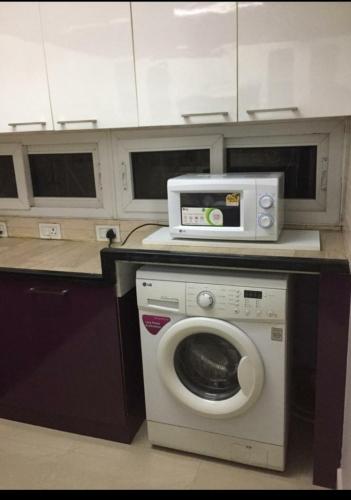 钦奈Avvairam Service Apartment - C9的厨房配有洗衣机和微波炉。