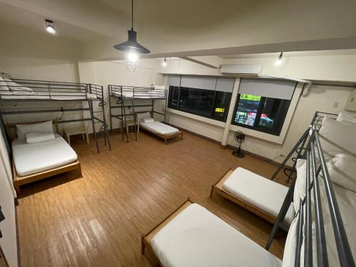 嘉义市Chiayi Petite Hostel的客房设有三张双层床和一个阳台。