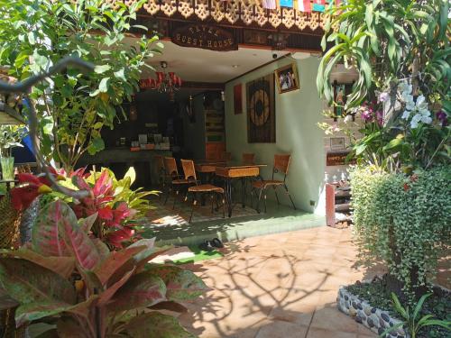 曼谷TAVEE Guesthouse的庭院配有桌椅和植物