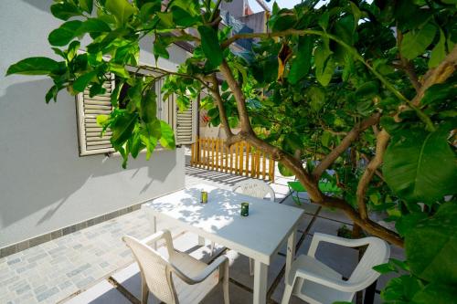 卡坦扎罗Mini Appartamento con giardino in centro的天井上种有树,配有桌椅