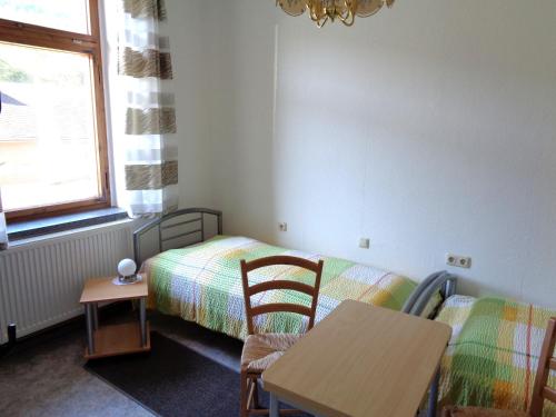 普罗布斯特采拉Pension Bahnmeister的卧室配有一张床和一张桌子及椅子
