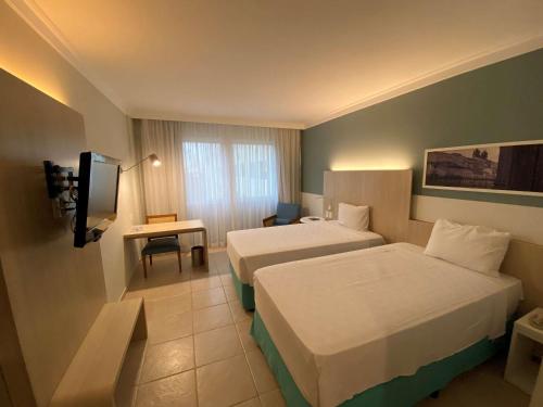 萨尔瓦多萨尔瓦多里奥福米罗美居酒店的酒店客房设有两张床和电视。