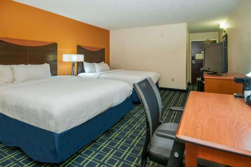 杰克逊Quality Inn & Suites的酒店客房设有两张床、一张桌子和一张桌子。