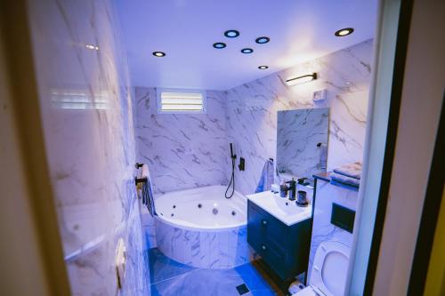 埃拉特Orel suite的蓝色和白色的浴室设有浴缸和水槽