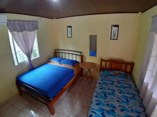 圣卡塔利娜岛Oceans Hostal的一间卧室设有两张床、一张桌子和一个窗口