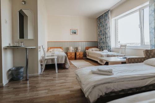 库雷萨雷Staadioni Hotel的一间带两张床的卧室和一间客厅