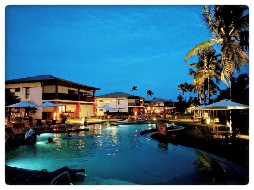 伊塔齐米林Bali Bahia Itacimirim的夜间在度假村的一个大型游泳池
