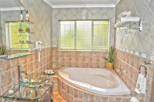 米德兰Ipe Tombe Guest Lodge - Midrand的带浴缸和窗户的大浴室