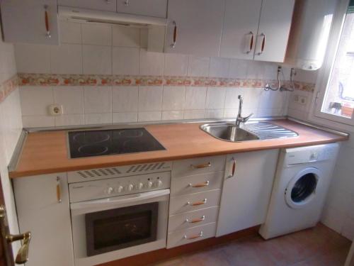 马德里M17 Madrid Centro apartamento con wifi的厨房配有水槽和炉灶 顶部烤箱