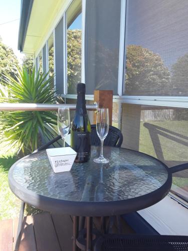 圣伦纳兹Bay Bell Cottage的一张桌子,上面放着一瓶葡萄酒和两杯酒