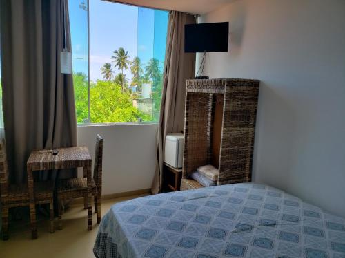 塔曼达雷热带海岸酒店的一间卧室设有一张床和一个美景窗户。