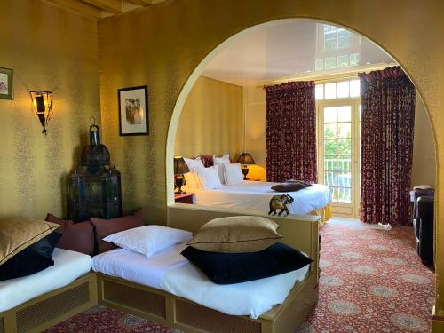 埃特勒塔圣克莱尔 - 第戎地区酒店的一间卧室设有两张带拱门的床。
