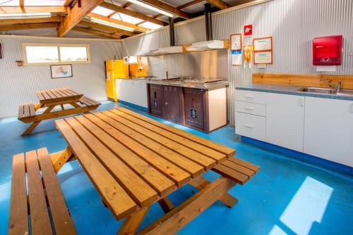 德文港Discovery Parks - Devonport的一个带木长椅和桌子的大厨房