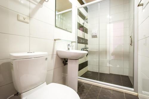 恒春古城Kenting Muchen INN的浴室配有卫生间、盥洗盆和淋浴。