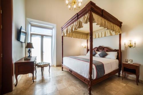 韦拉克鲁斯Hotel Imperial的一间卧室设有四柱床和窗户。