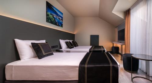 伊斯坦布尔MENALO HOTEL PREMIUM ISTANBUL AIRPORT的酒店客房设有两张床和一张桌子。