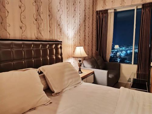 贝克西Grand Kamala Lagoon by 21 Room Netflix的酒店的客房 - 带一张床、椅子和窗户