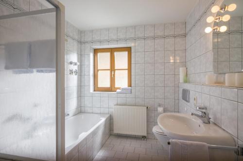 奥博奥多夫Christophenhof的白色的浴室设有浴缸和水槽。