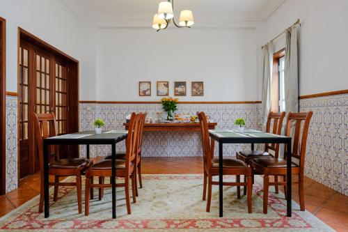 加亚新城Classico Guesthouse的用餐室配有2张黑色桌子和木椅