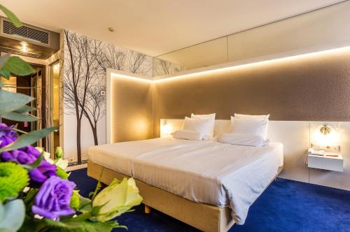 普罗夫迪夫普罗夫迪夫大酒店的配有大床和鲜花的酒店客房