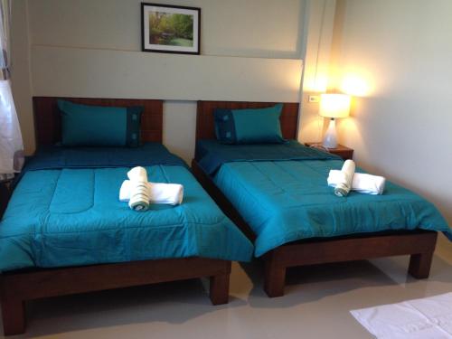 甲米镇城市之家旅馆的配有两张床铺的客房配有蓝色床单和白色枕头