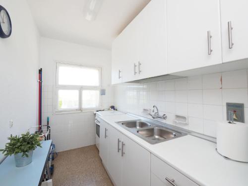 德拉塞尔瓦港奥古斯公寓的白色的厨房设有水槽和窗户
