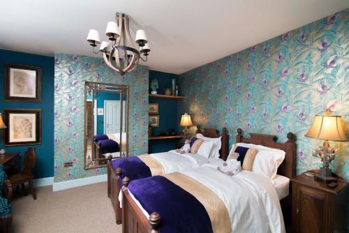 约克普劳酒店的一间卧室设有两张带蓝色墙壁和镜子的床