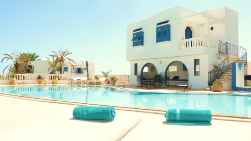 米多恩Dar Amphora Menzel的房屋前的游泳池配有2个蓝色枕头