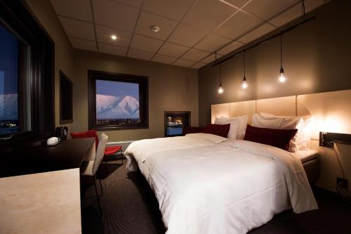 朗伊尔城斯瓦尔巴德酒店的卧室配有一张白色大床和一张书桌