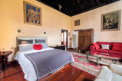 加拉奇科Casa Tradicional Canaria的一间卧室配有一张床和一张红色的沙发
