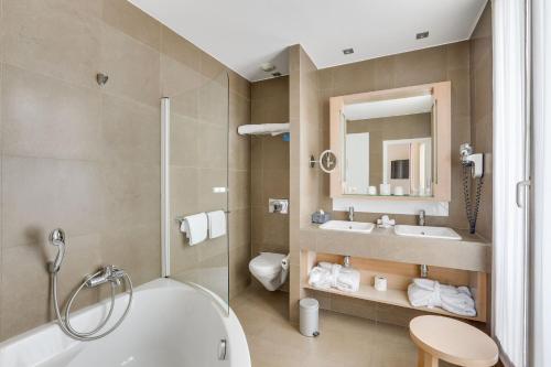 巴黎Hotel Duret Paris的带浴缸、卫生间和盥洗盆的浴室
