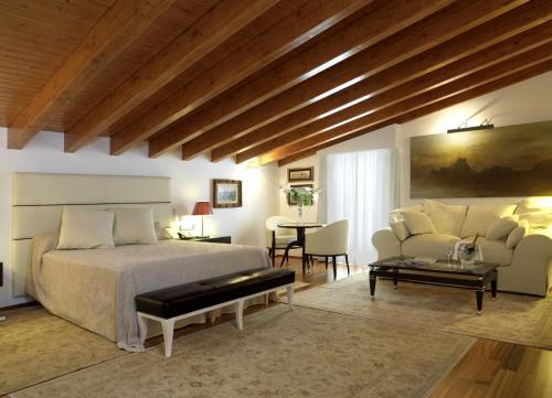 伊维萨镇Mirador de Dalt Vila-Relais & Chateaux的一间卧室配有一张床、一张沙发和一张桌子