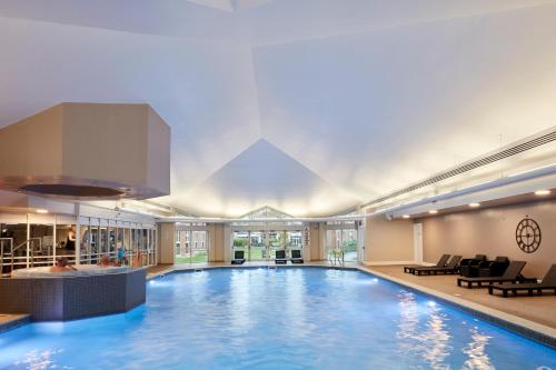 纽波特凯尔特庄园科尔德拉科特酒店的酒店的大型游泳池配有桌椅