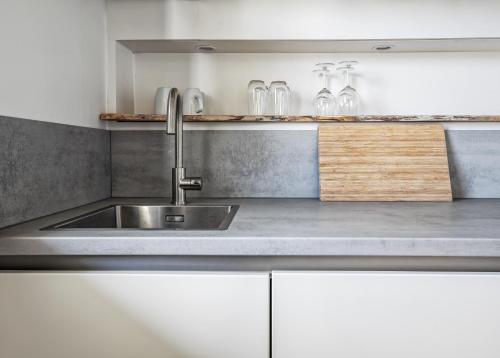 德科赫Appartementen Sonnenhof的厨房配有不锈钢水槽和白色橱柜