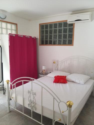 哥西尔Sympa Aquaverde entre mer et campagne的卧室配有白色的床和红色窗帘